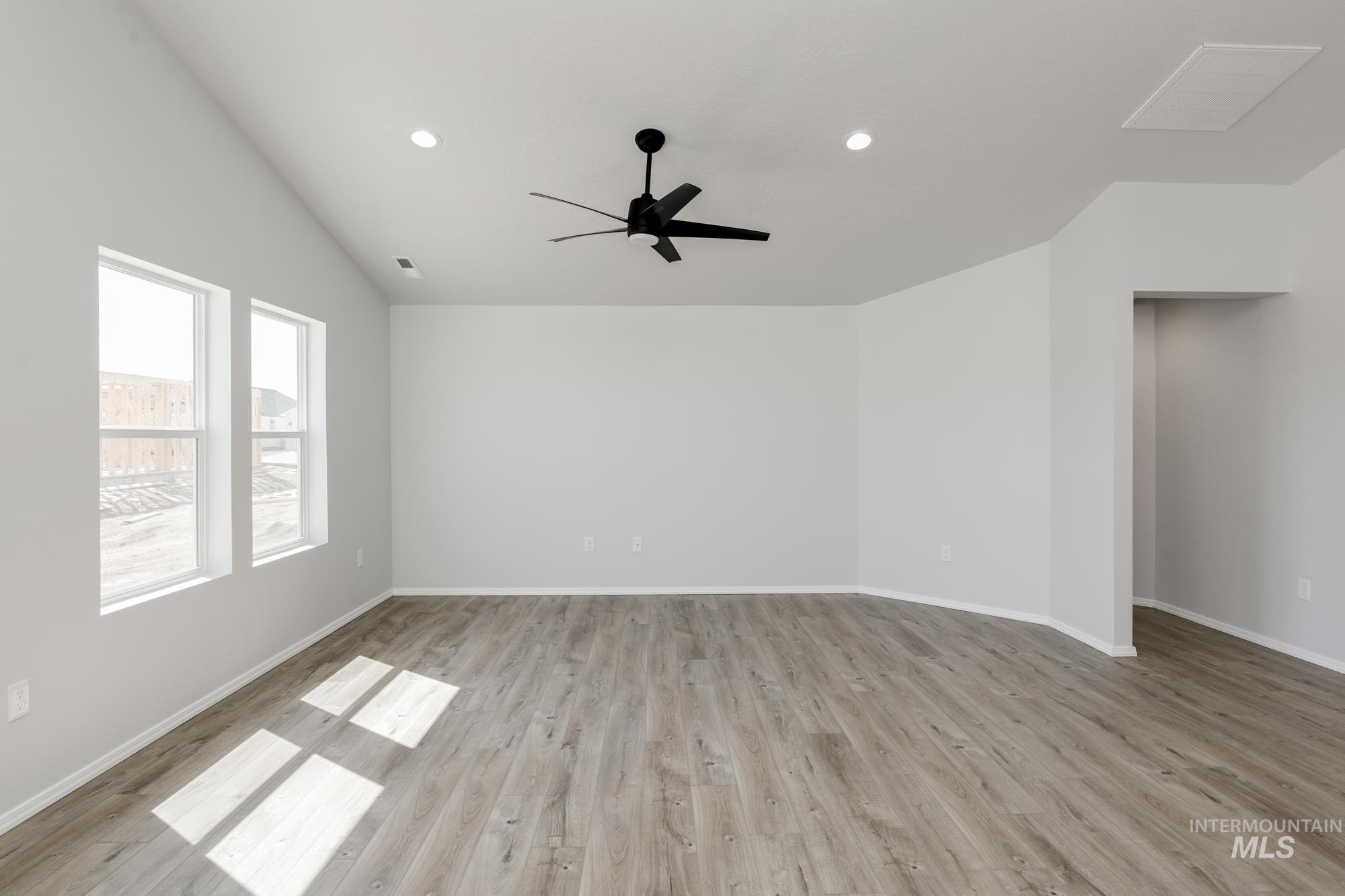 Spare room featuring recessed lighting, light wood-style flooring, vaulted ceiling, and a ceiling fan