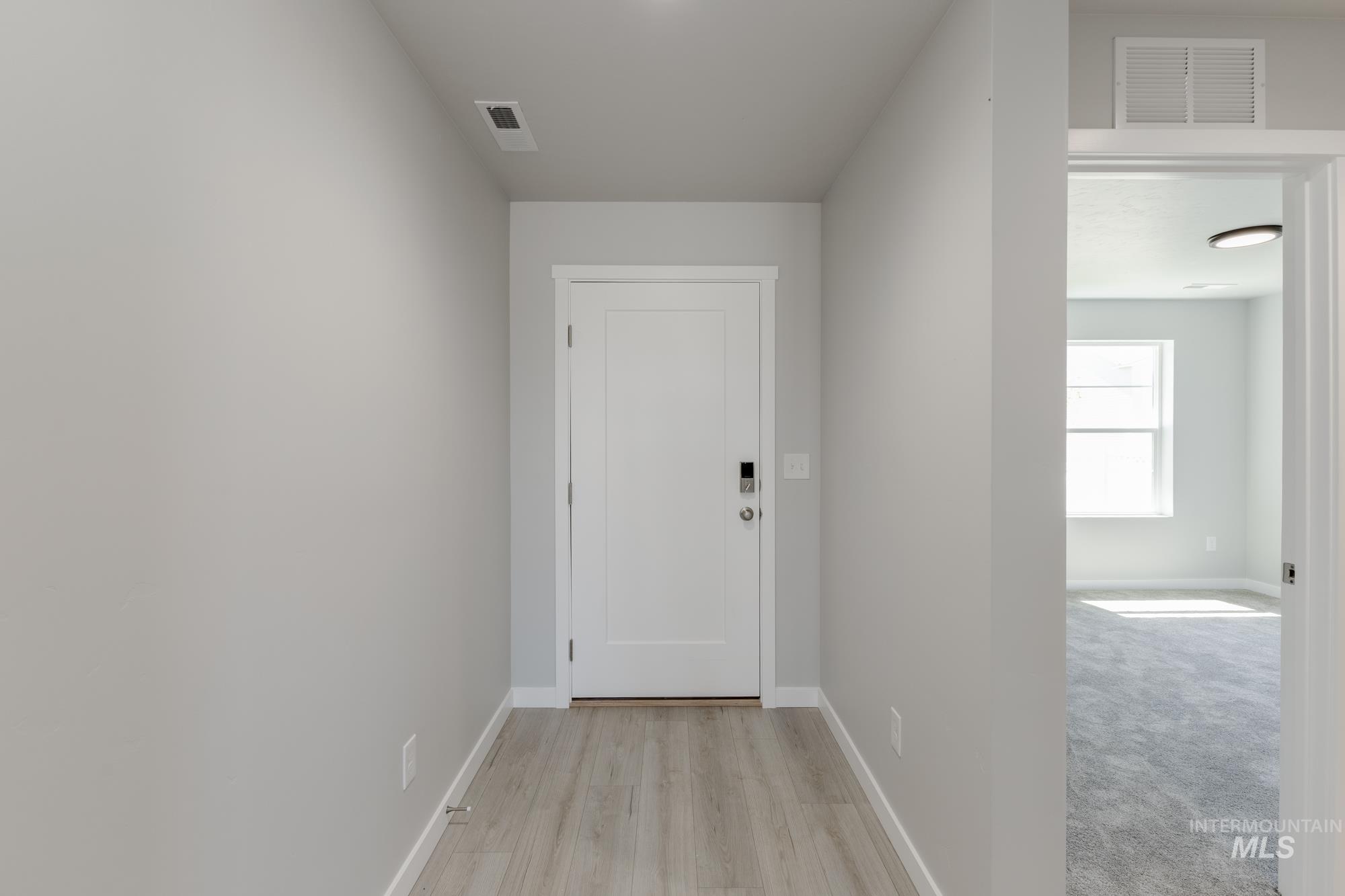 Hallway with baseboards and light wood-style flooring