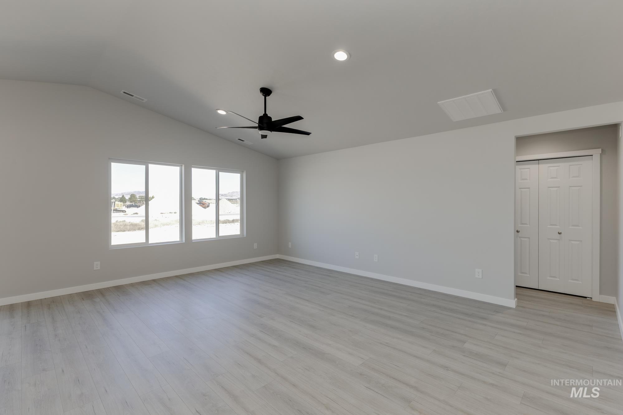 Spare room featuring light wood-style floors, recessed lighting, vaulted ceiling, and ceiling fan