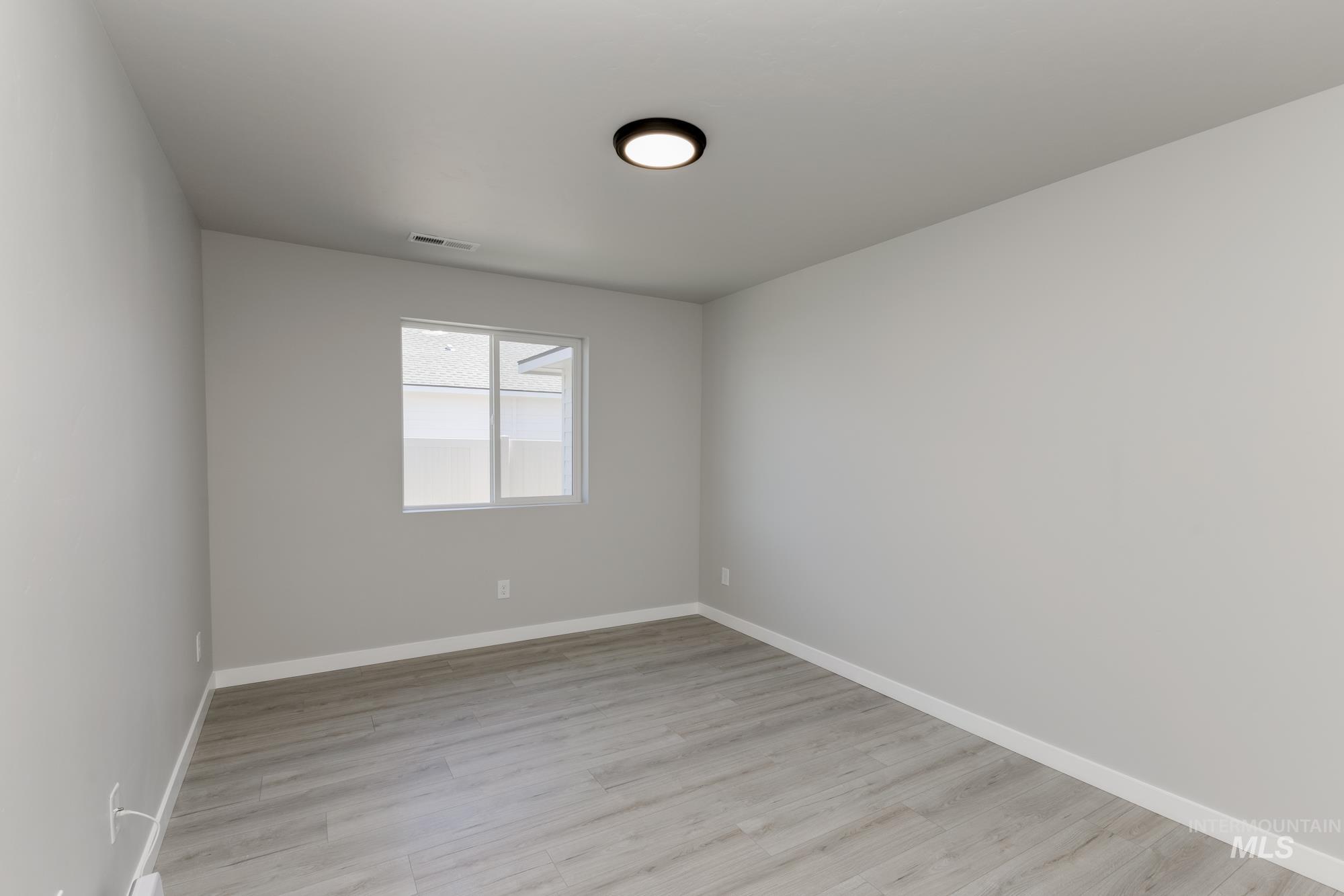 Empty room featuring light wood finished floors and baseboards
