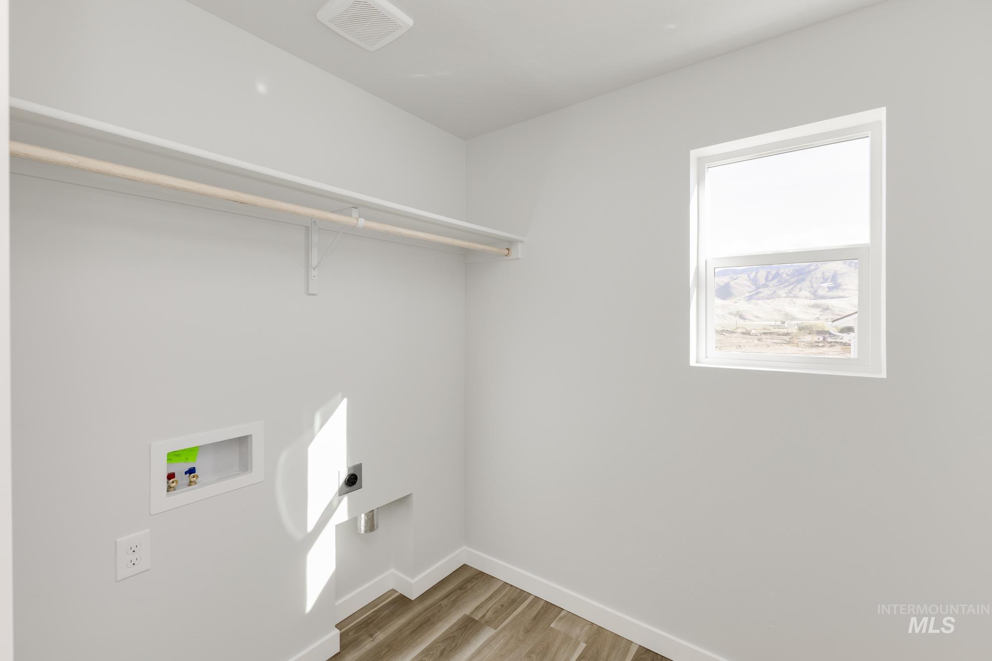 Washroom featuring light wood-style floors, washer hookup, and electric dryer hookup