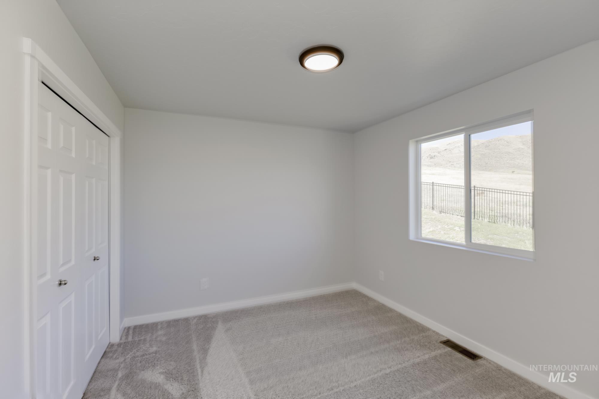 Unfurnished bedroom with light carpet and a closet