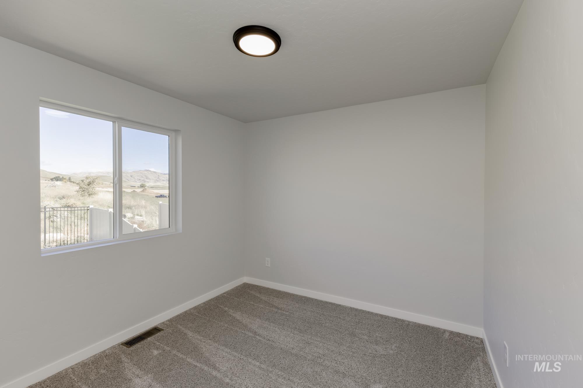 Carpeted empty room featuring baseboards