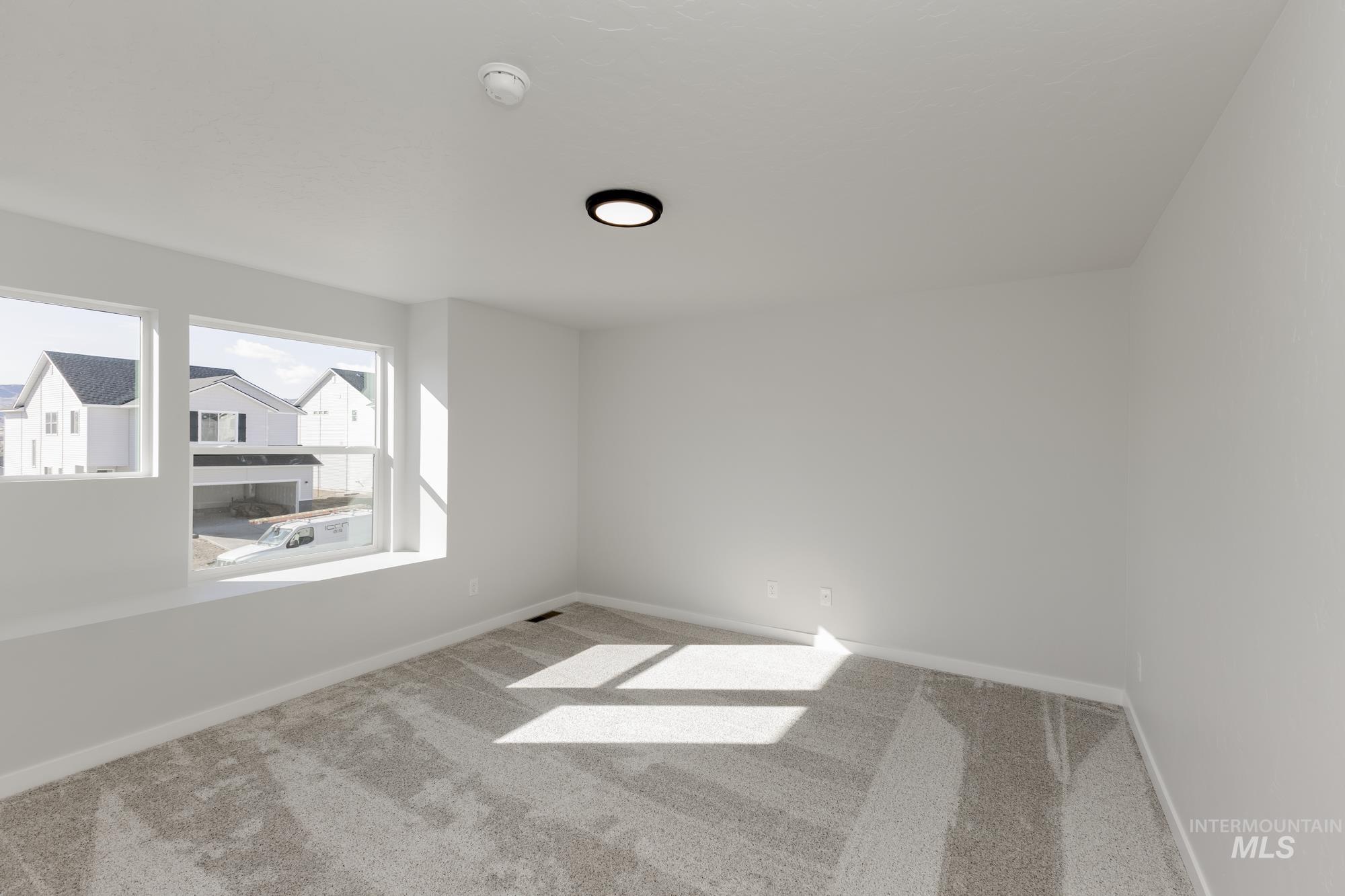 Carpeted empty room with baseboards