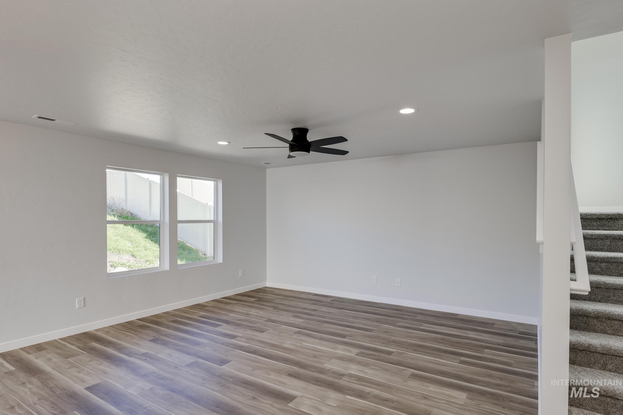 Spare room with stairway, wood finished floors, recessed lighting, and a ceiling fan
