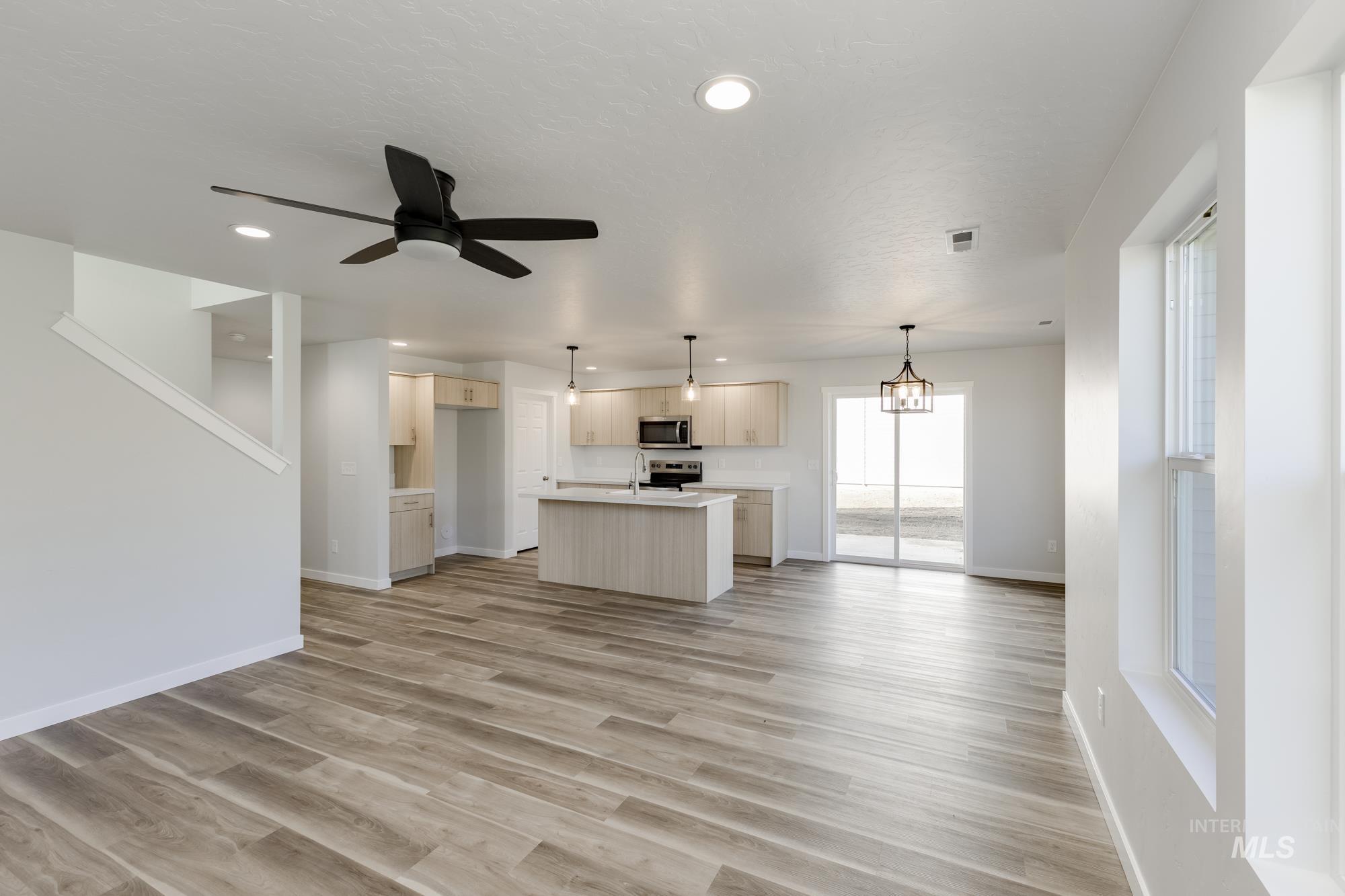 Unfurnished living room with light wood-style floors, a ceiling fan, and recessed lighting