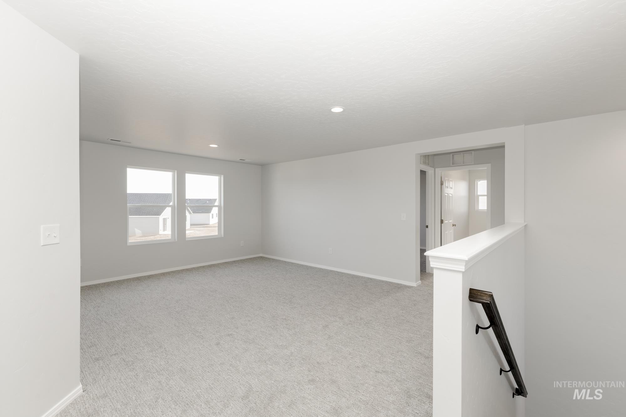 Unfurnished room with light colored carpet and recessed lighting