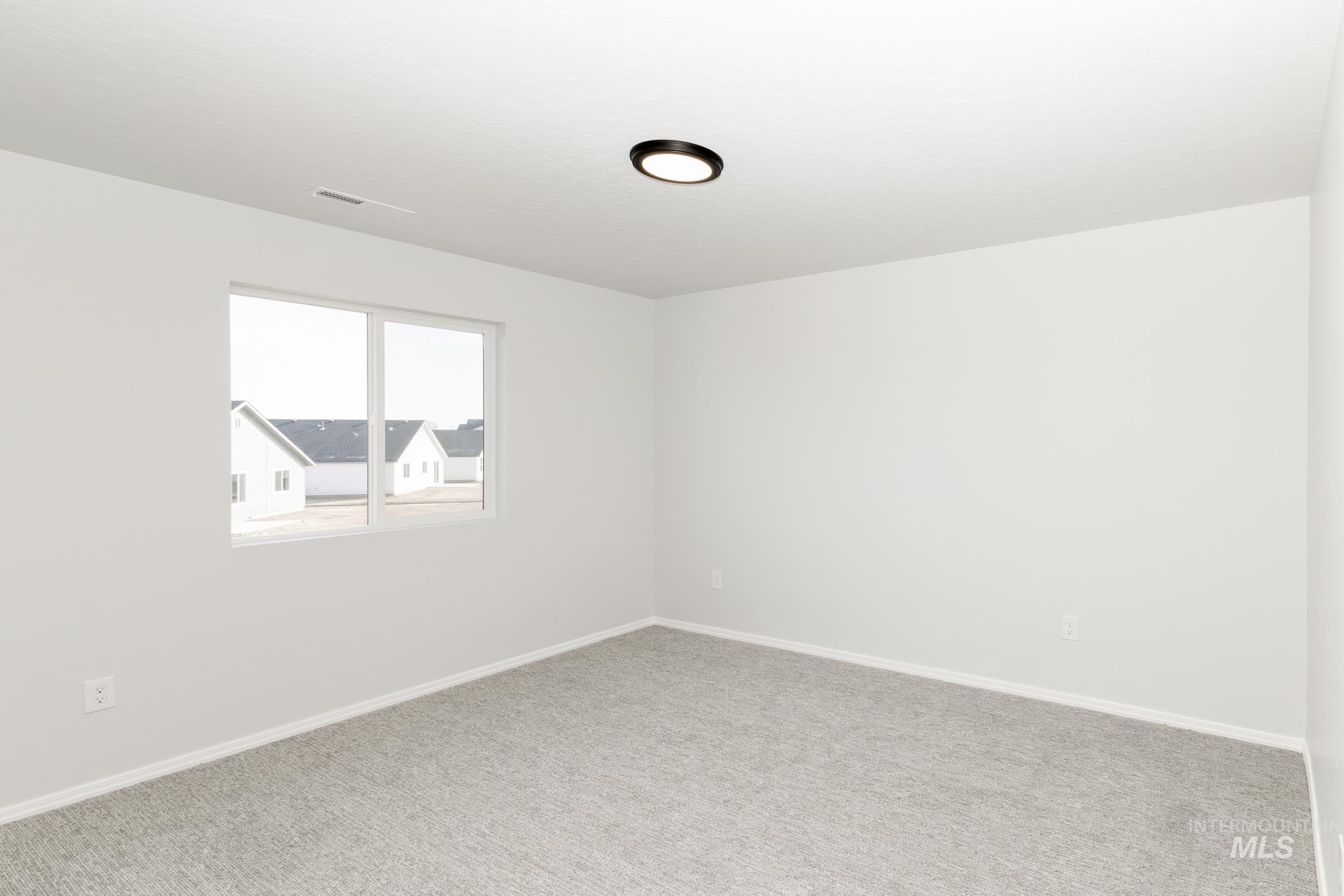 Spare room with baseboards and carpet