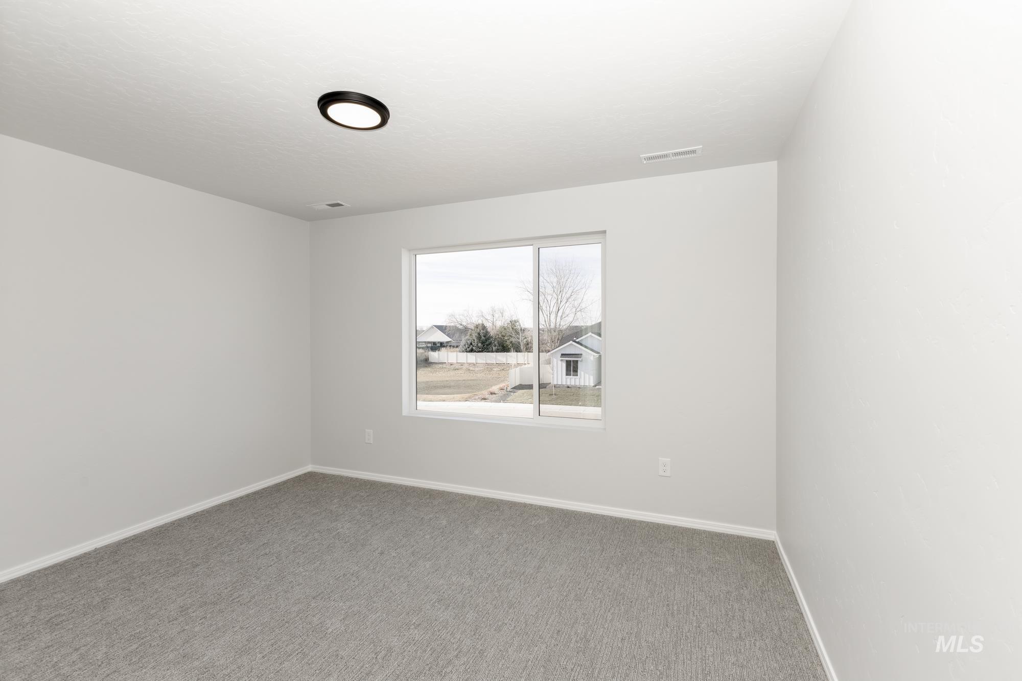 Spare room featuring carpet floors and baseboards