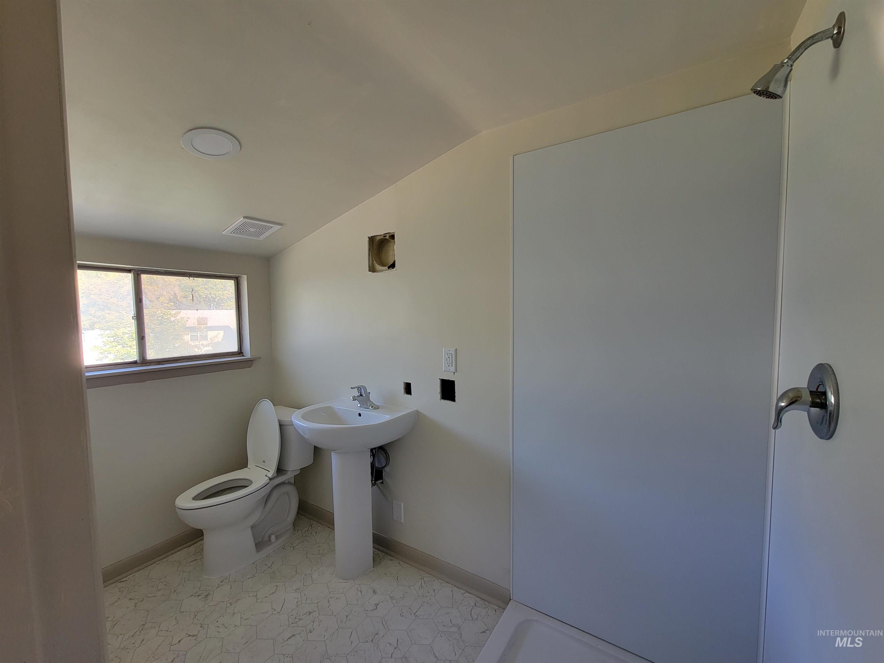 Bathroom with baseboards and vaulted ceiling