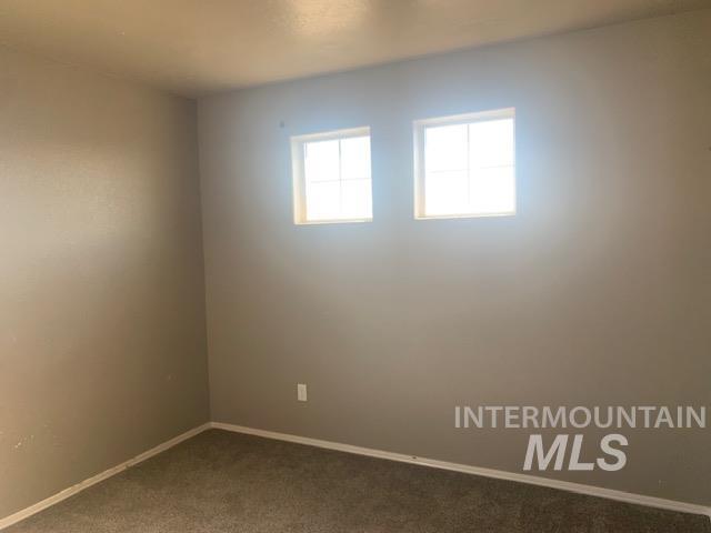 Unfurnished room featuring baseboards and carpet