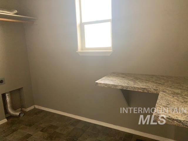 Laundry area with baseboards and hookup for an electric dryer