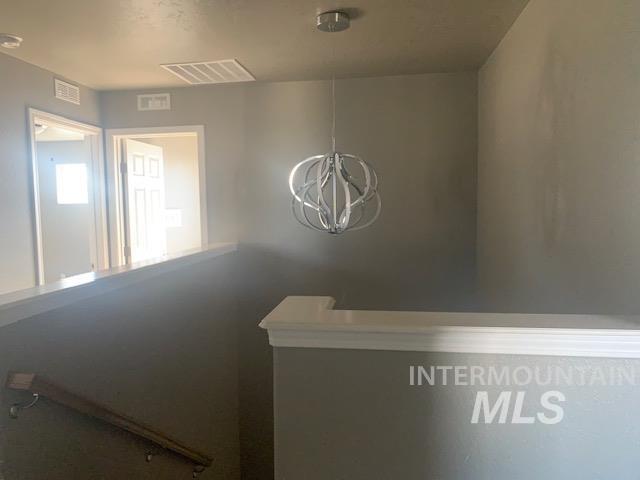 Corridor featuring a chandelier