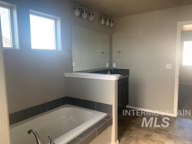 Full bathroom with vanity and a garden tub