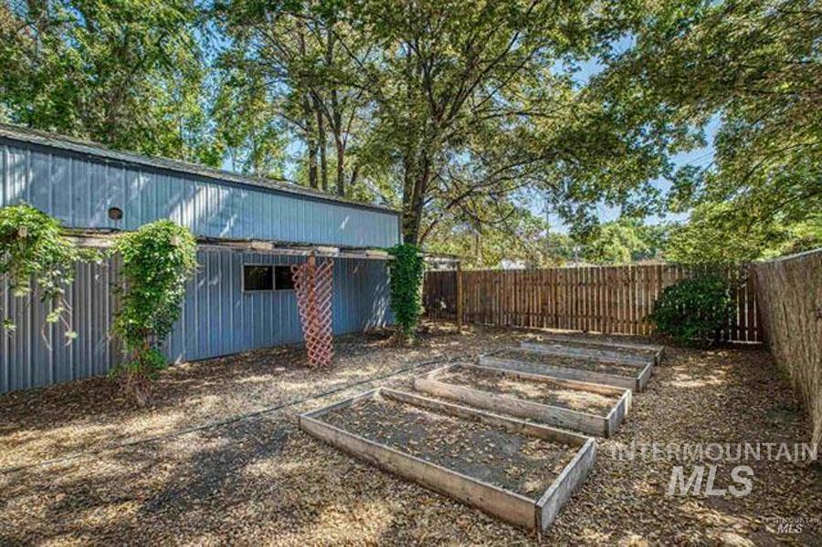 Fenced backyard featuring a garden
