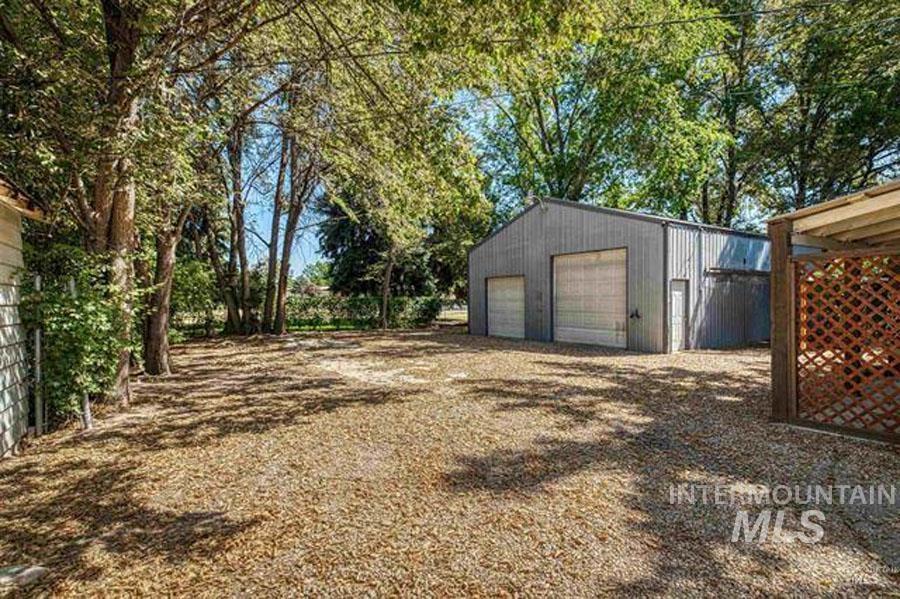 View of yard with an outdoor structure and a detached garage