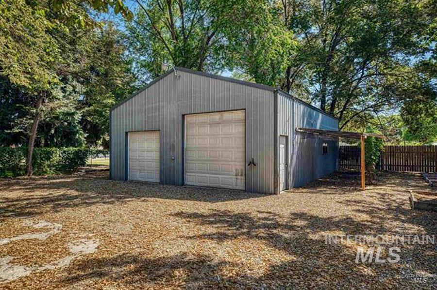 Detached garage with view of scattered trees
