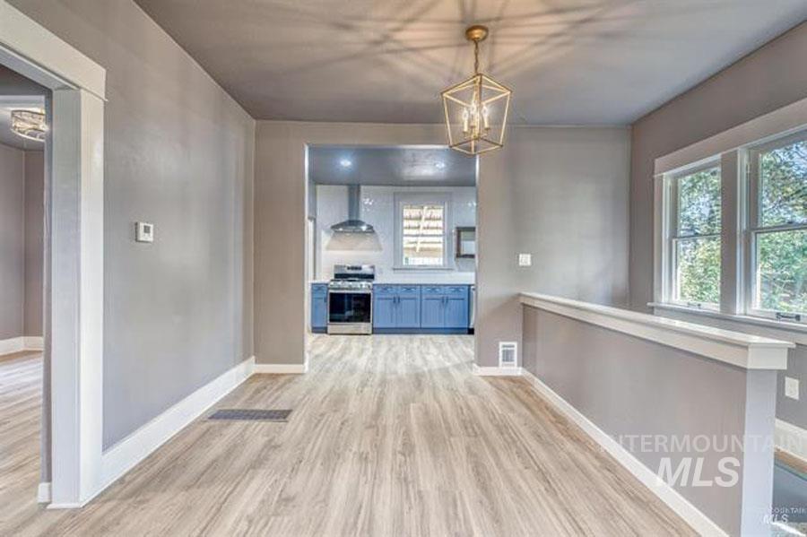 Unfurnished dining area with light wood finished floors and a chandelier