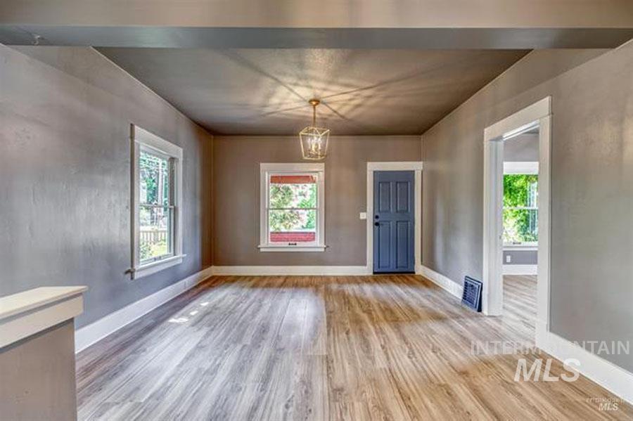 Unfurnished dining area with light wood-style flooring and a chandelier