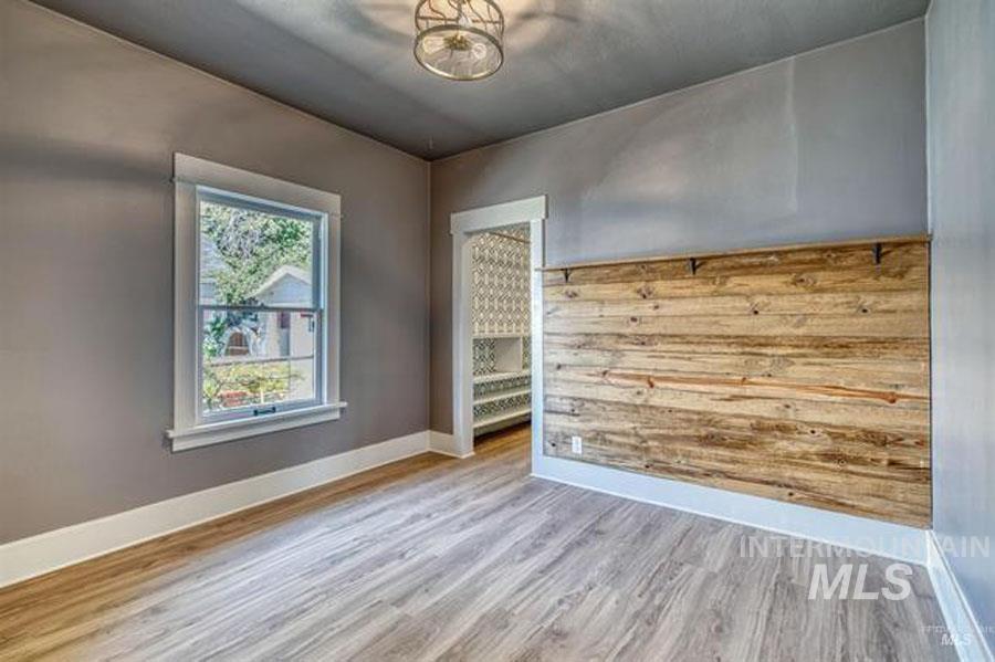 Spare room featuring baseboards and light wood-type flooring