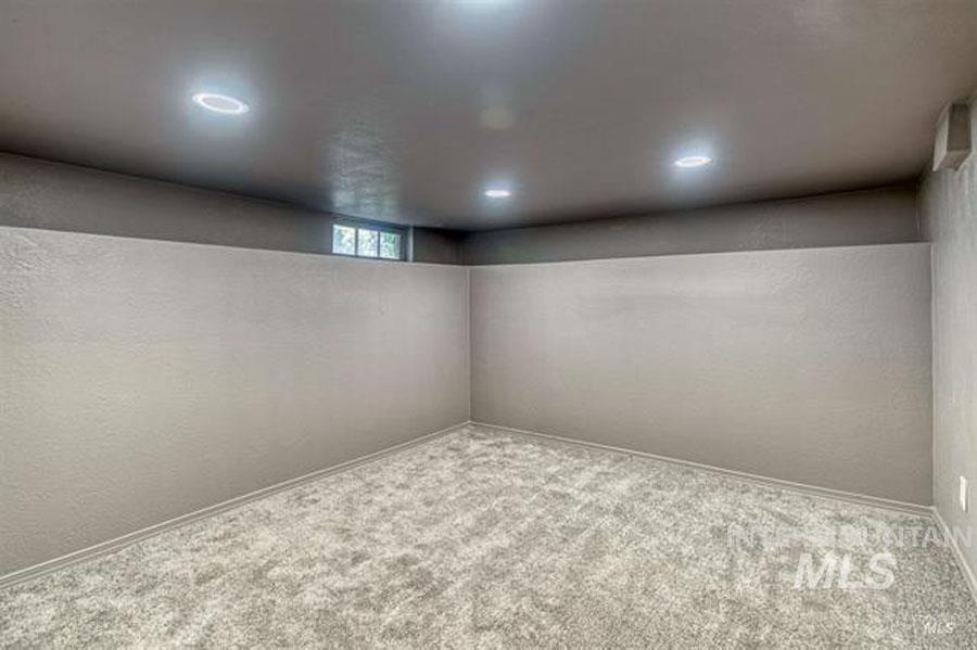 Basement featuring a textured wall and carpet floors