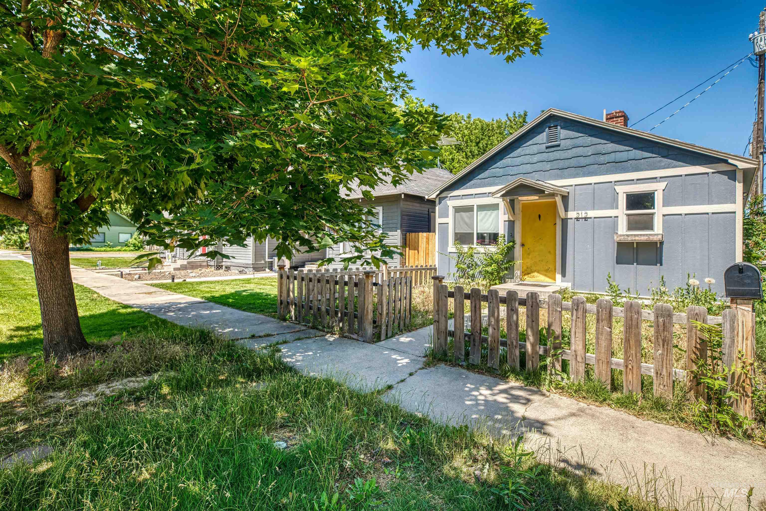 Bungalow-style house with a chimney and a fenced front yard