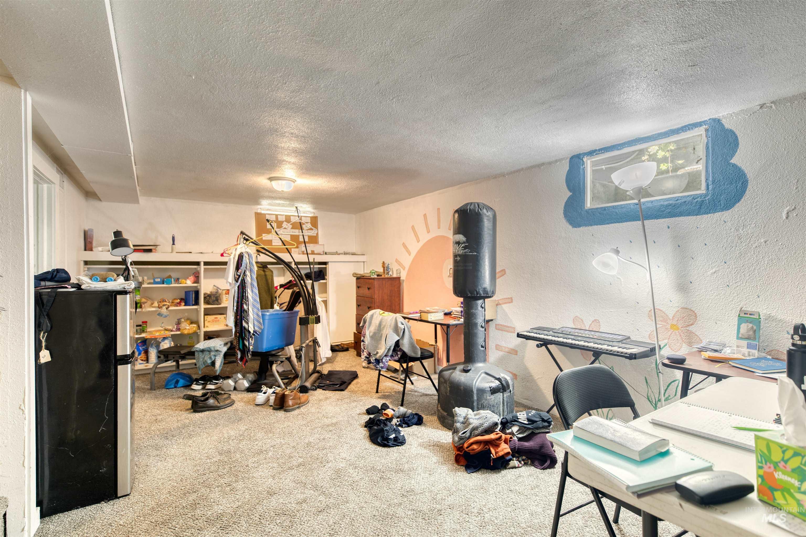 Exercise room featuring carpet flooring, a textured ceiling, and a textured wall