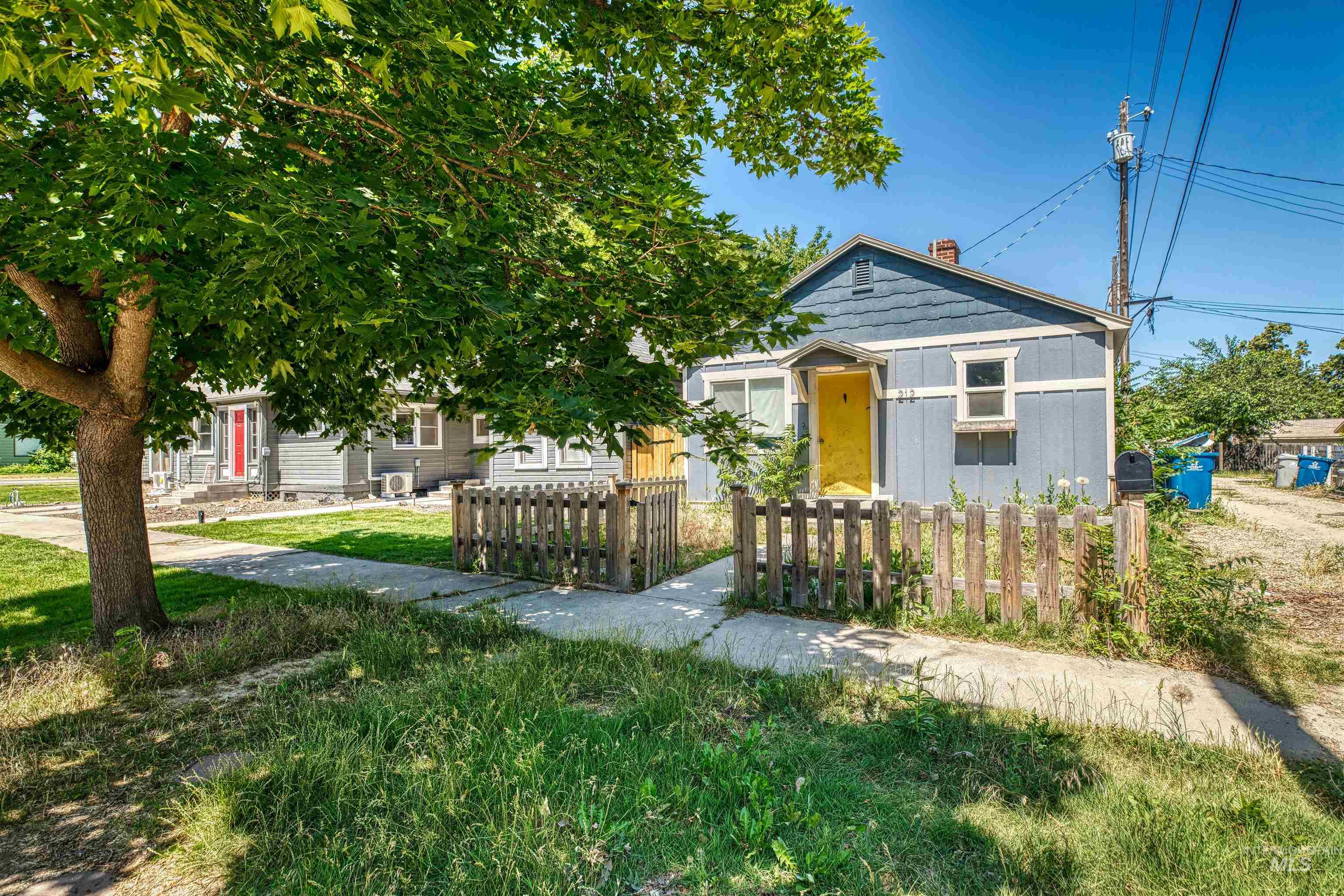 Bungalow featuring a chimney and a fenced front yard