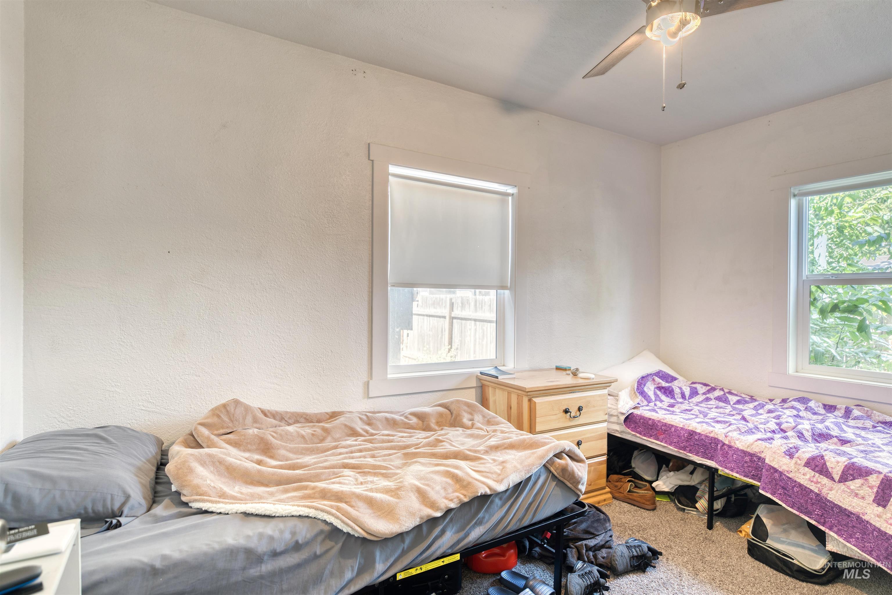 Carpeted bedroom featuring a ceiling fan