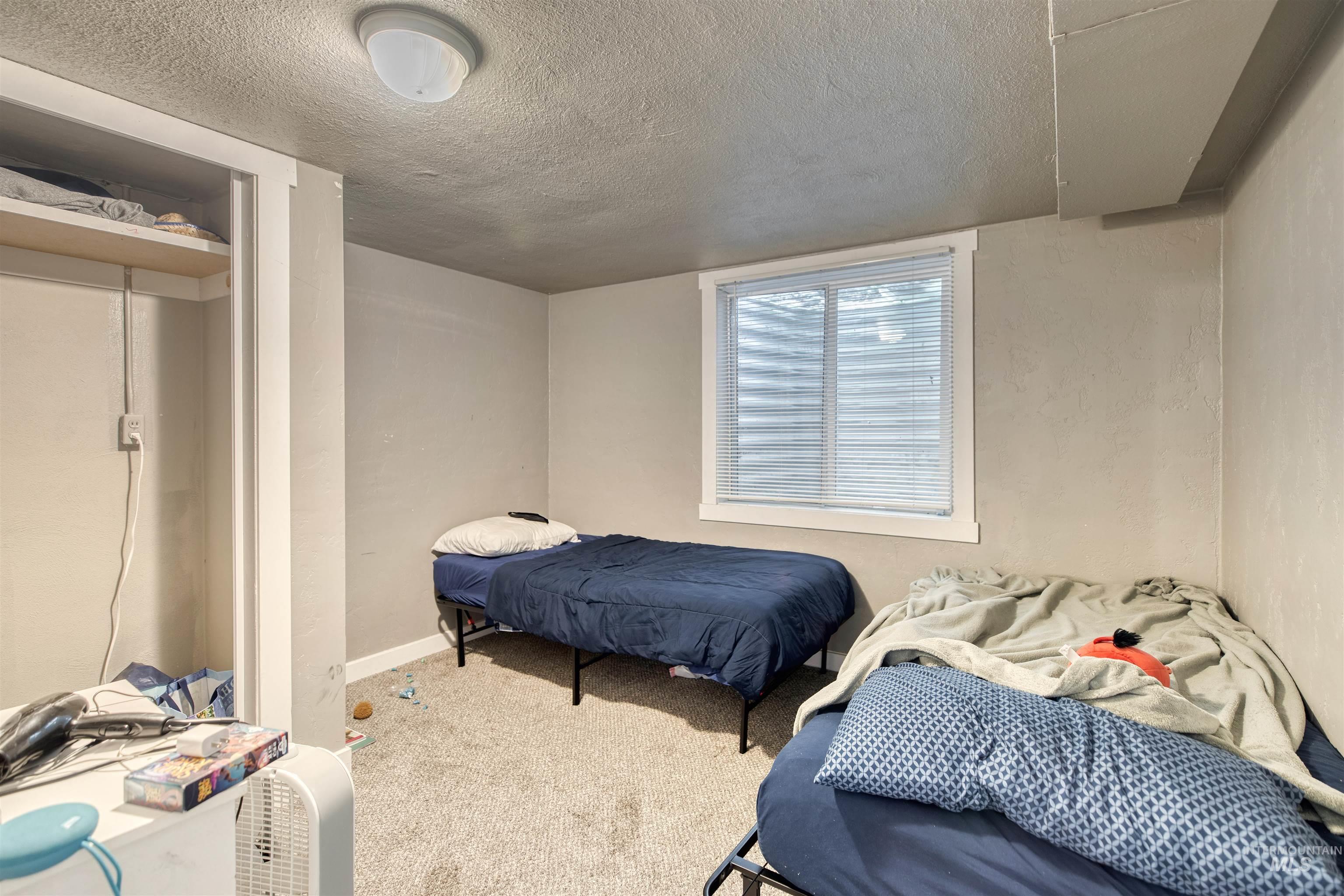 Bedroom featuring carpet, a textured ceiling, and a closet