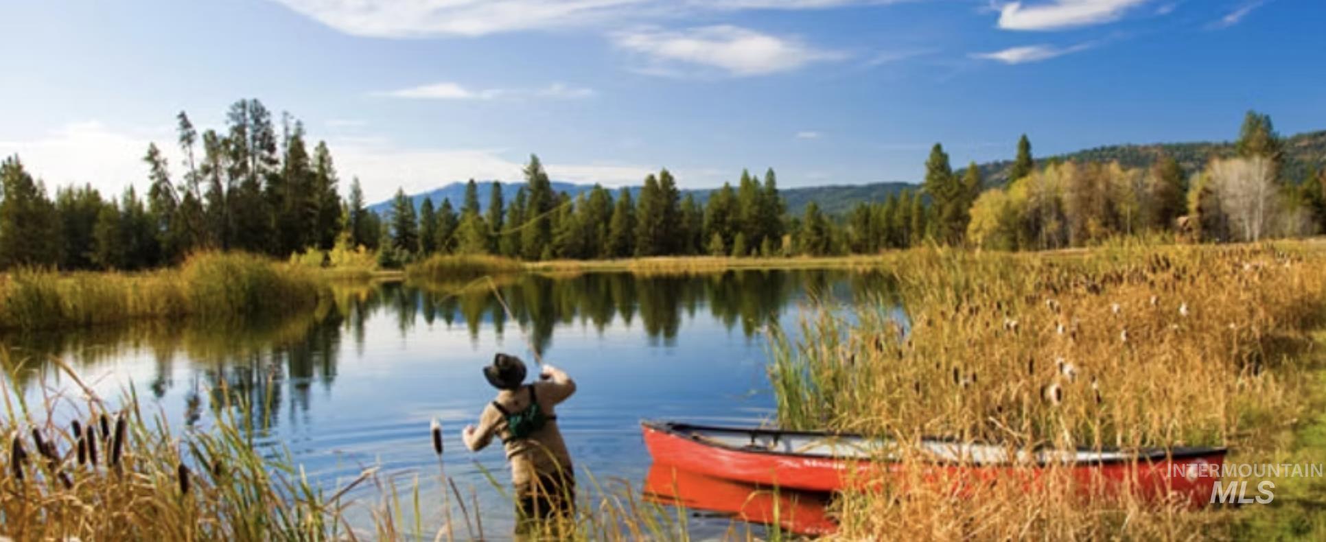 Water view with a heavily wooded area and a mountainous background