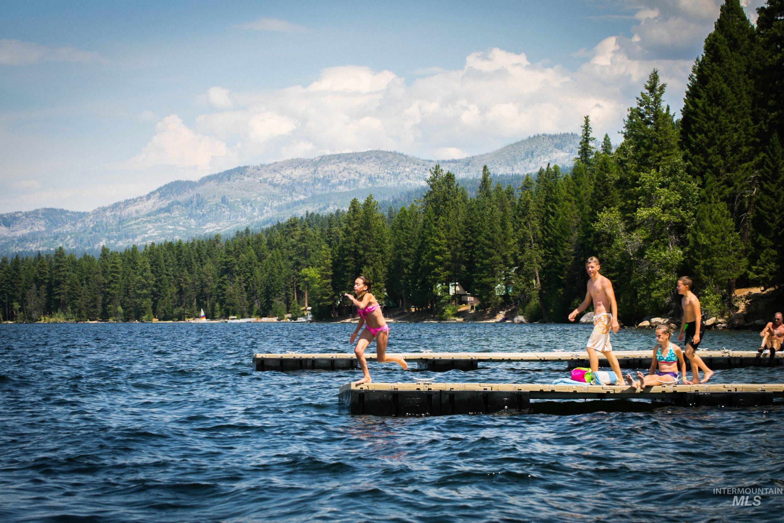 Dock with a water and mountain view and a wooded view