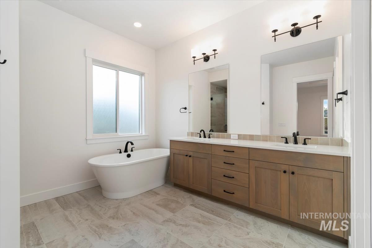 Full bathroom with a freestanding tub, double vanity, and a shower stall
