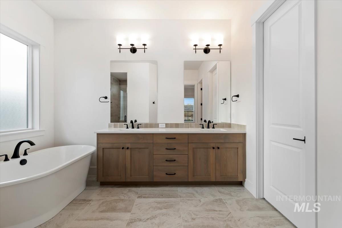 Full bath featuring a freestanding bath and double vanity