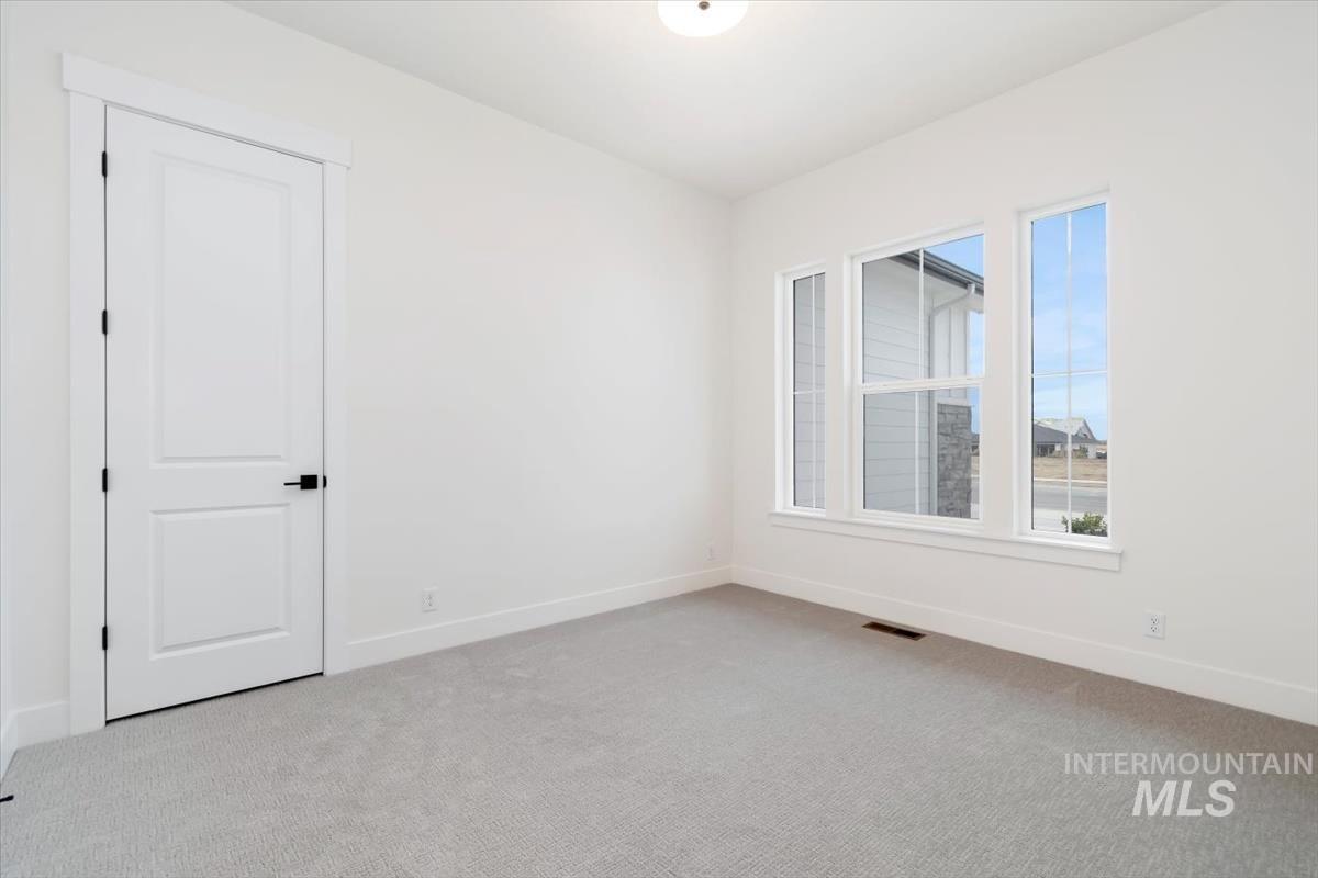 Carpeted empty room with baseboards