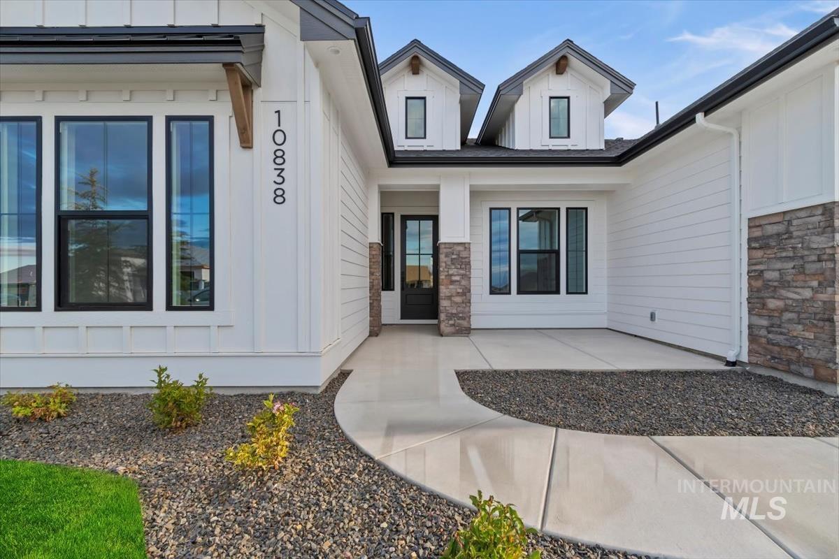 Doorway to property with covered porch and stone siding