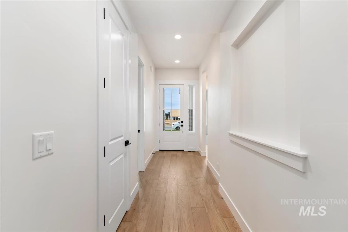 Corridor featuring light wood finished floors and recessed lighting