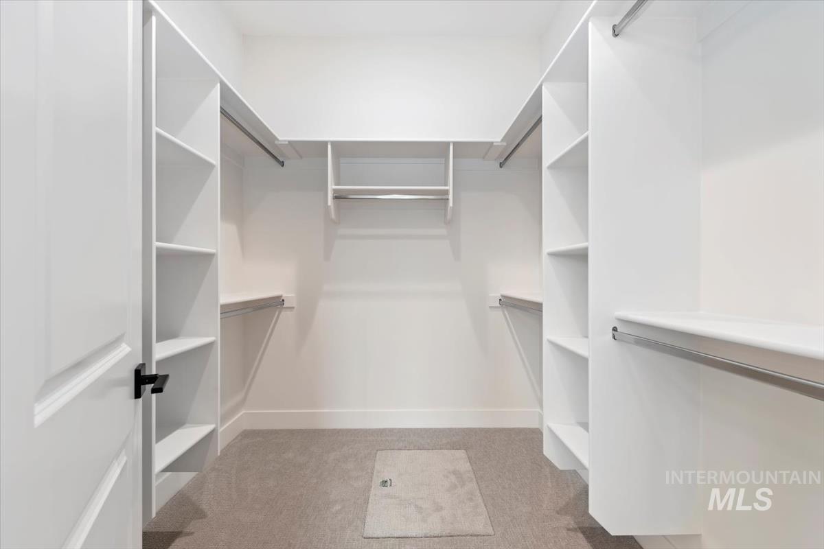 Spacious closet with light carpet
