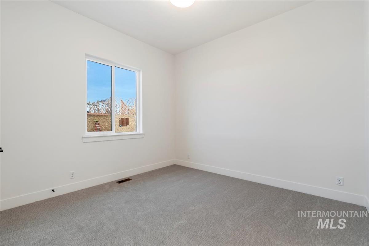 Empty room featuring baseboards and carpet