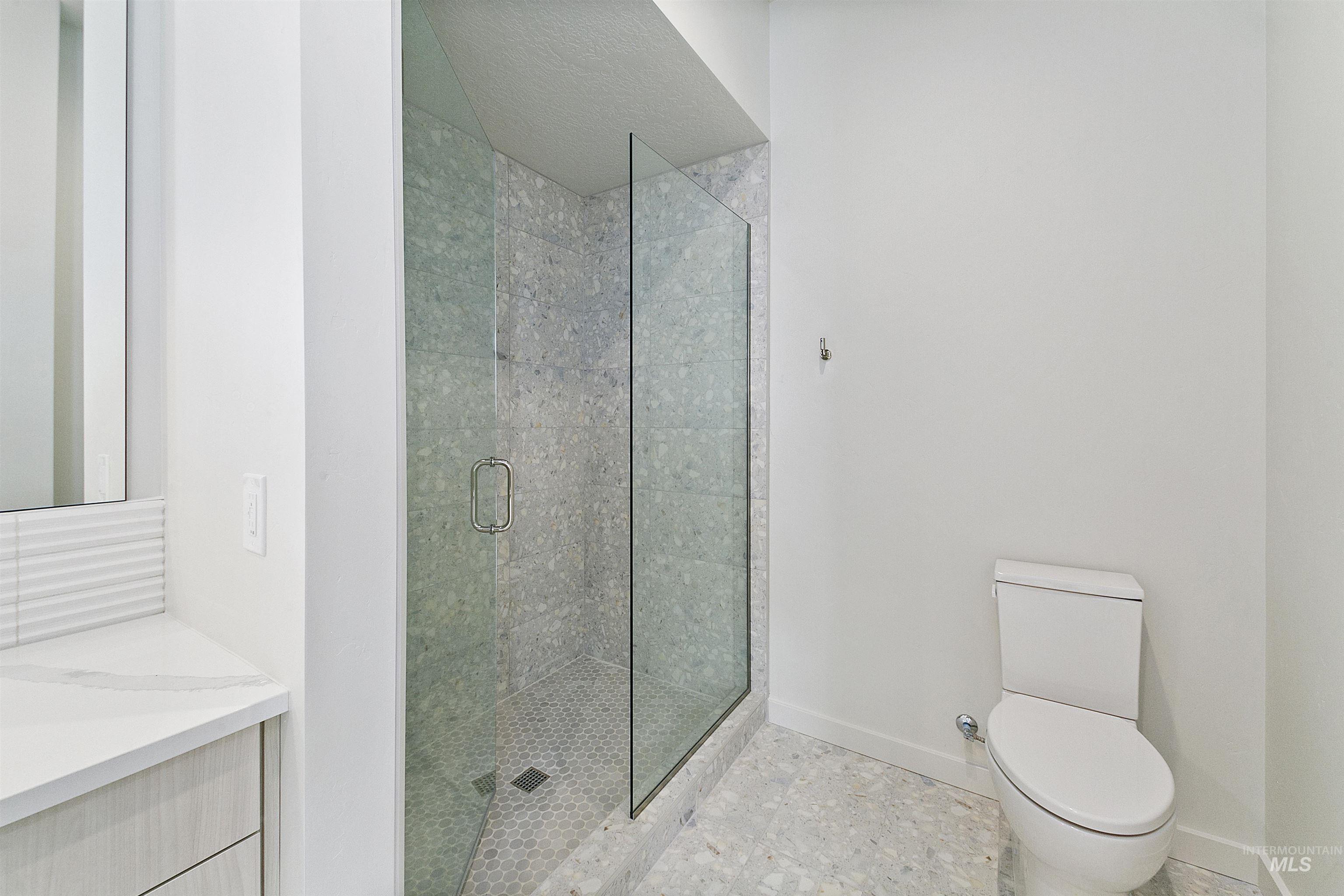 Bathroom with a stall shower and baseboards