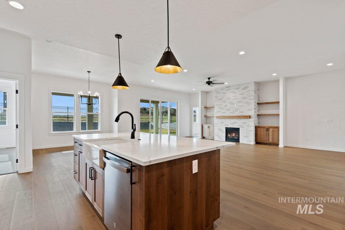 Kitchen with decorative light fixtures, light wood-type flooring, open floor plan, a kitchen island with sink, and recessed lighting