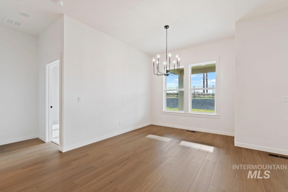Unfurnished dining area featuring a chandelier and light wood finished floors