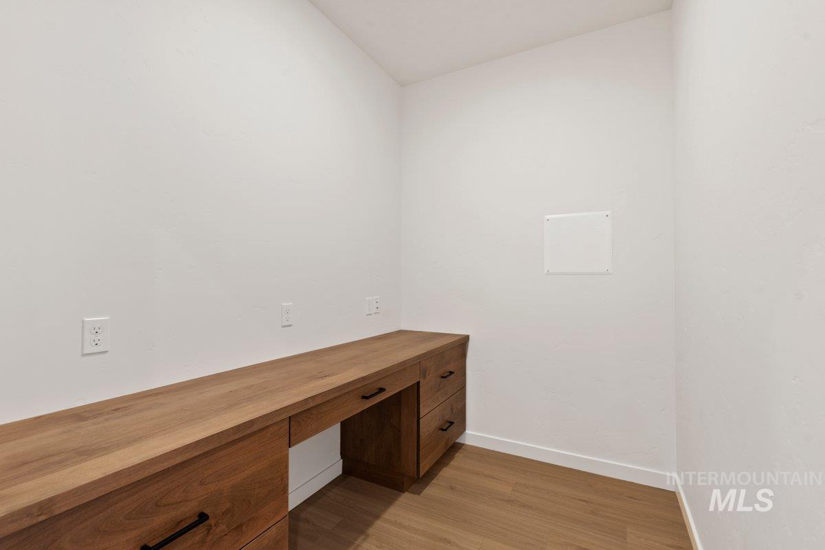 Unfurnished office featuring light wood-type flooring and built in study area