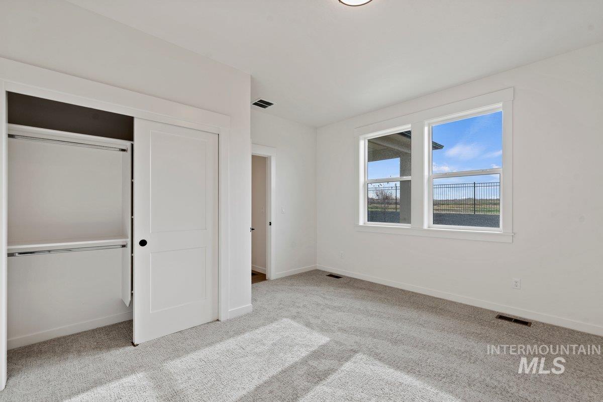 Unfurnished bedroom with light colored carpet and a closet