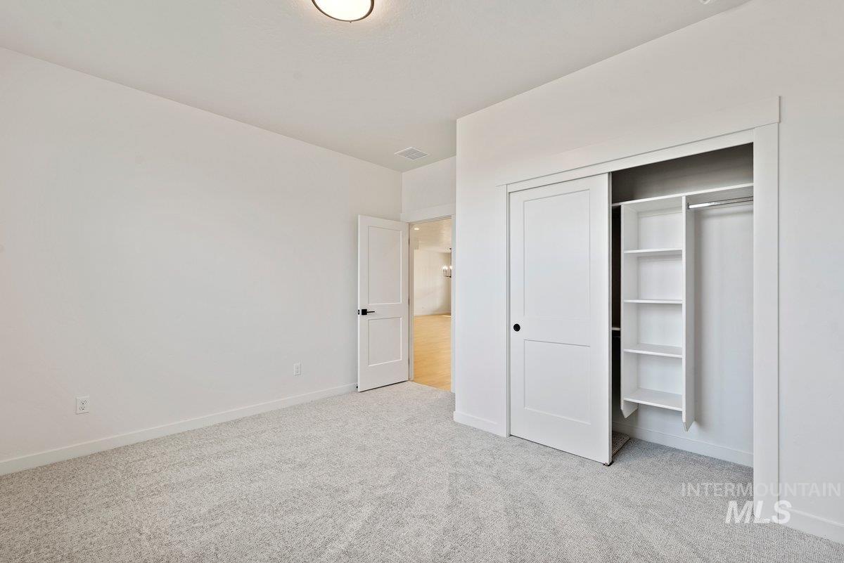 Unfurnished bedroom featuring light colored carpet and a closet