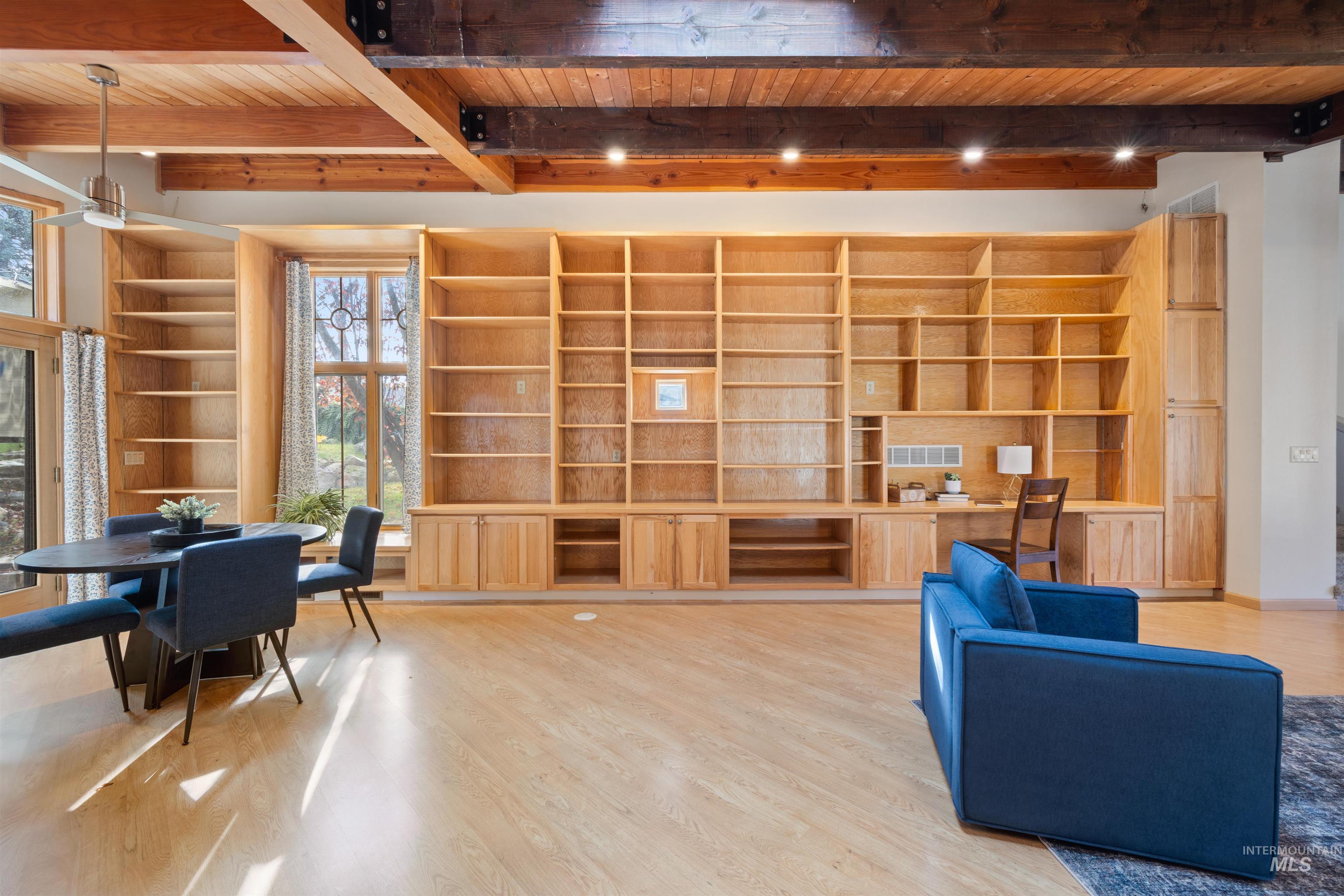 Living area featuring built in features, a wooden ceiling with exposed beams, and light wood-style floors