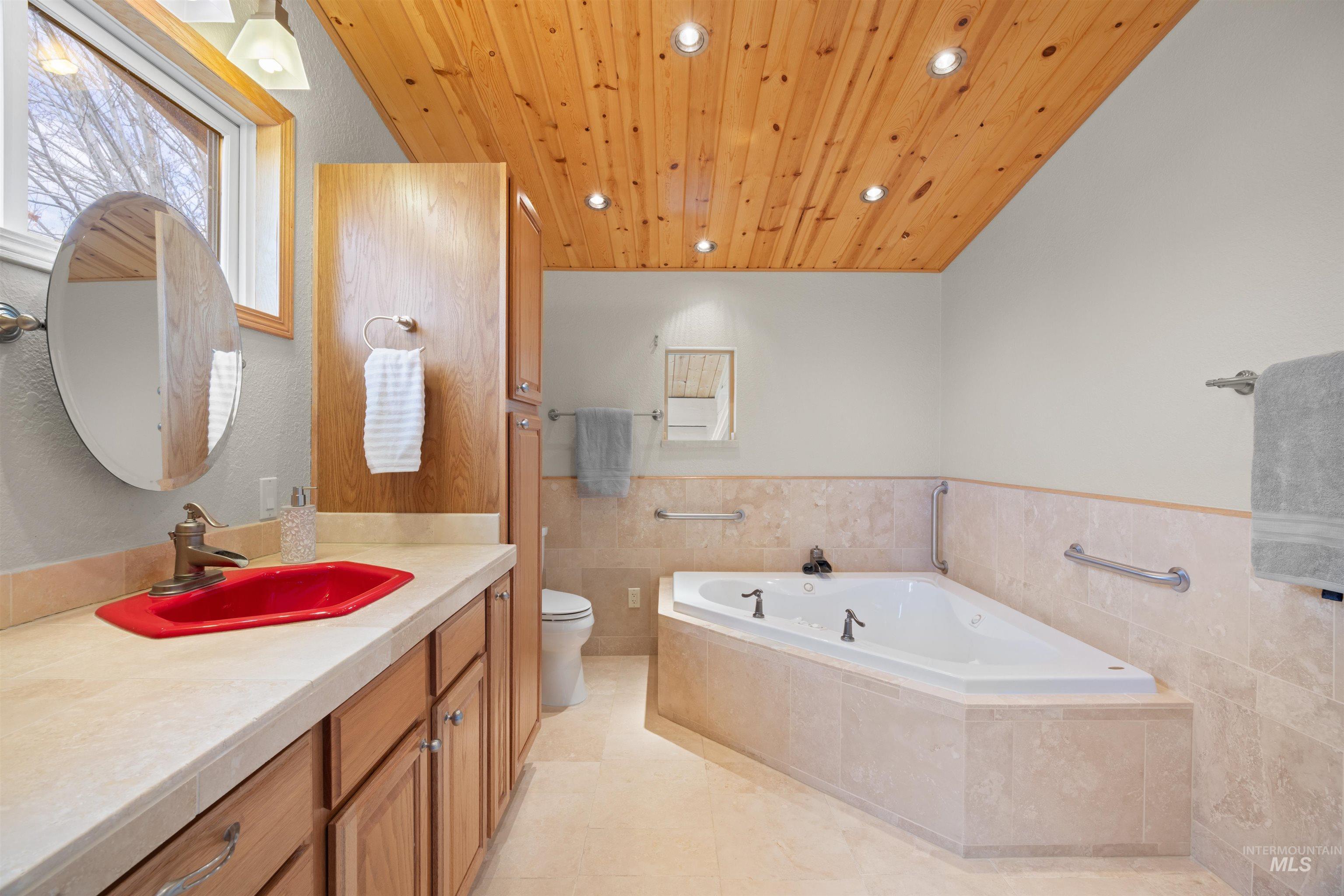 Full bathroom featuring vanity, a bath, wood ceiling, wainscoting, and recessed lighting