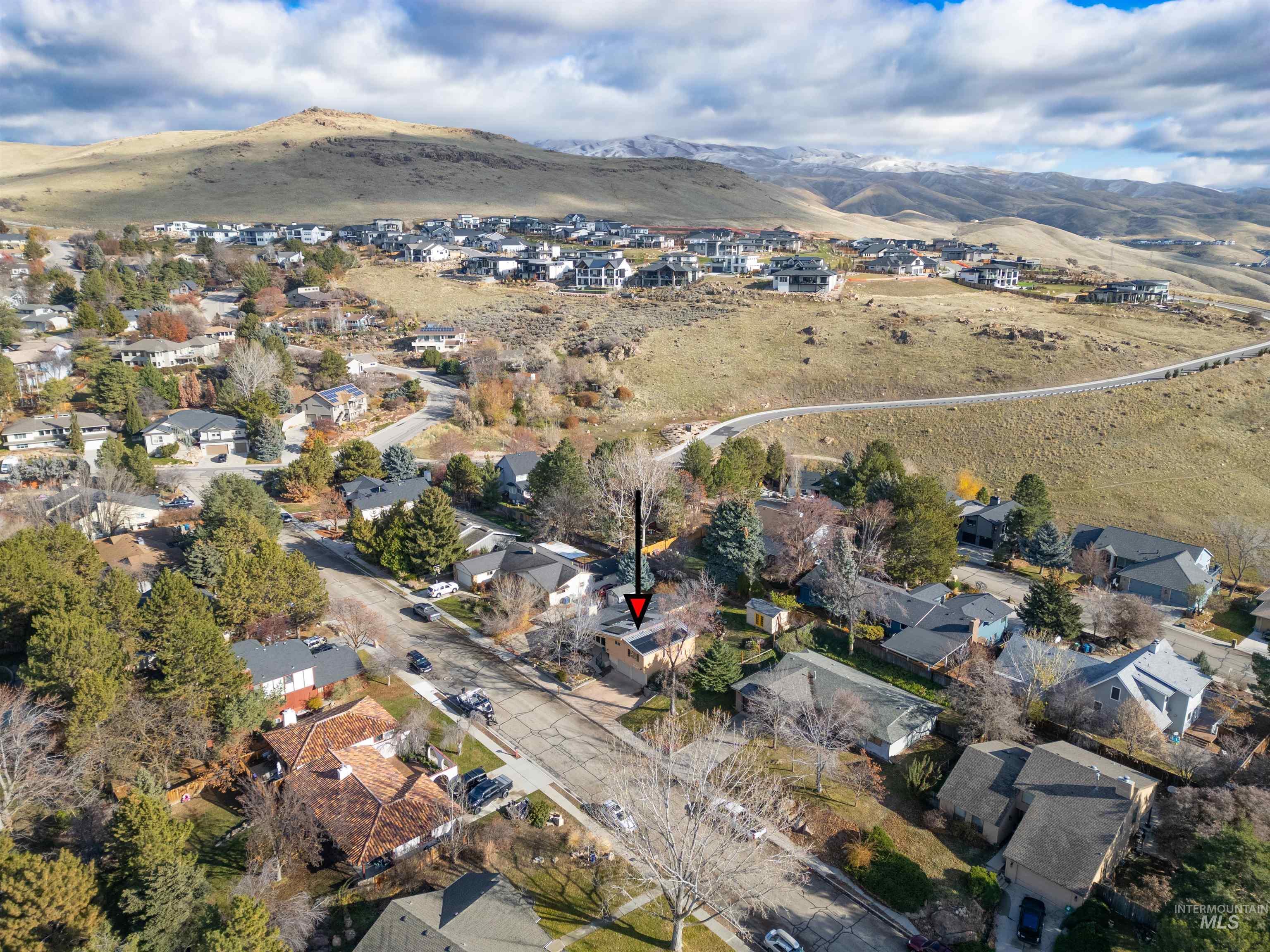 Aerial view of property and surrounding area with a mountainous background and nearby suburban area