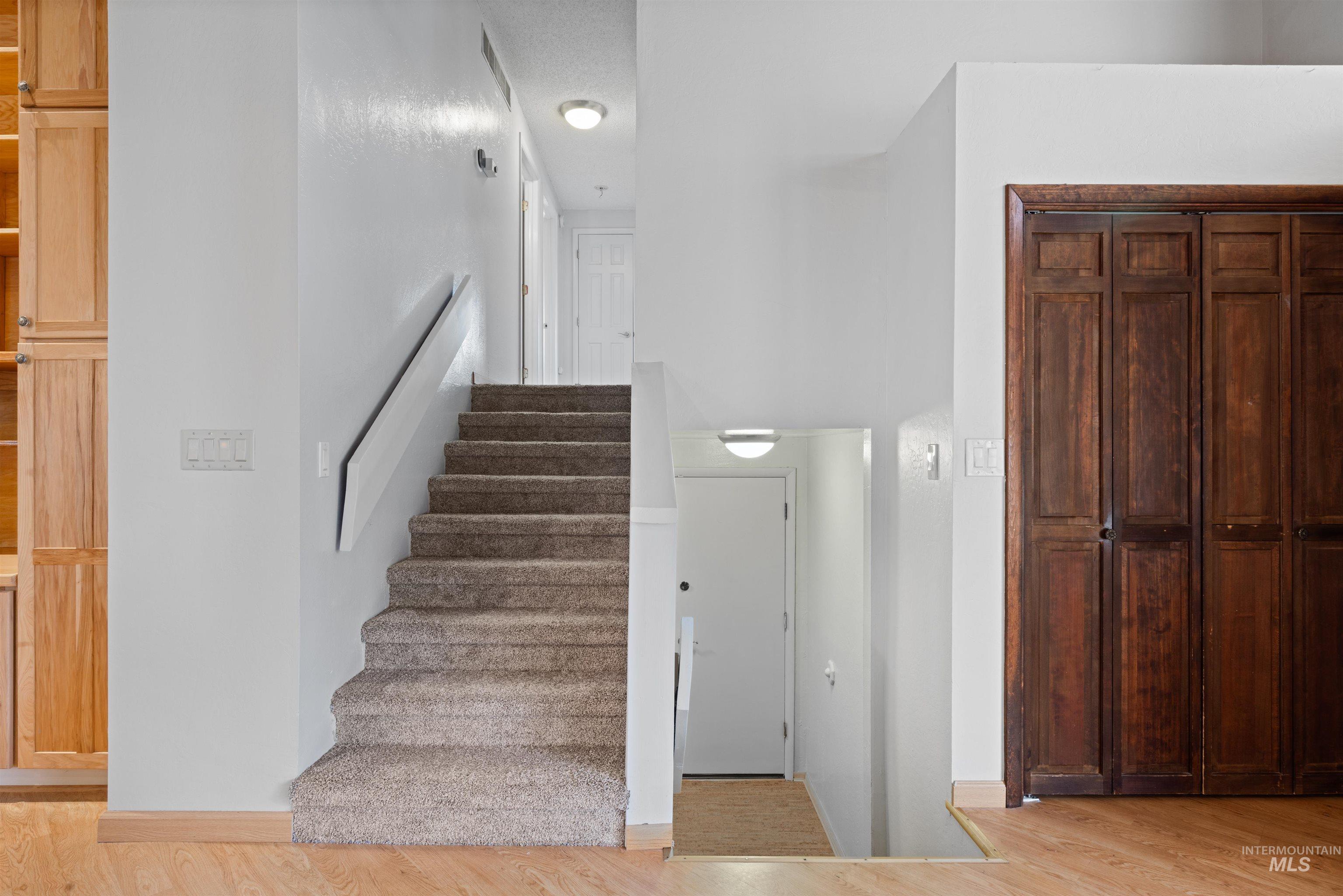 Stairway with wood finished floors and baseboards