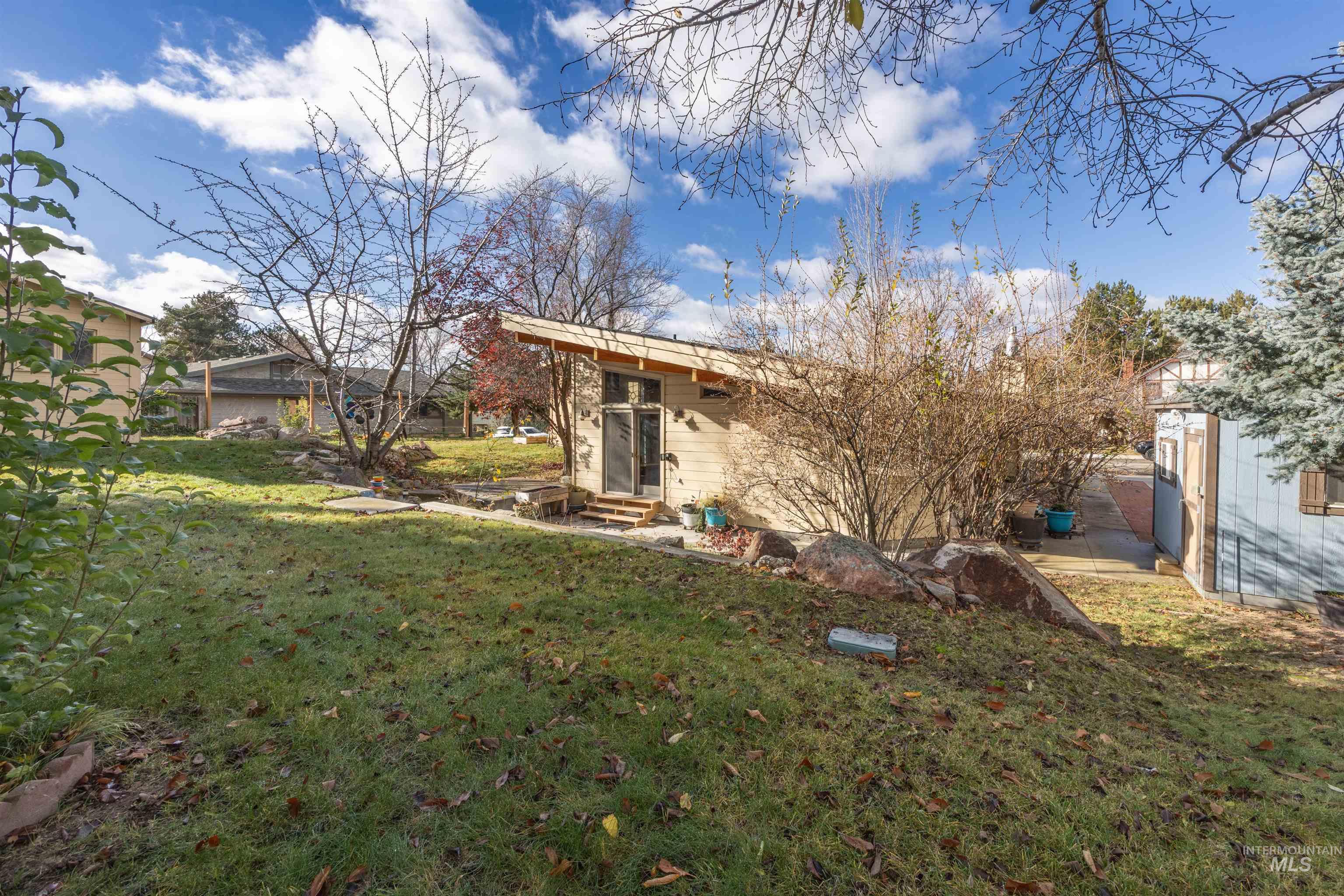 Rear view of property featuring a lawn and entry steps